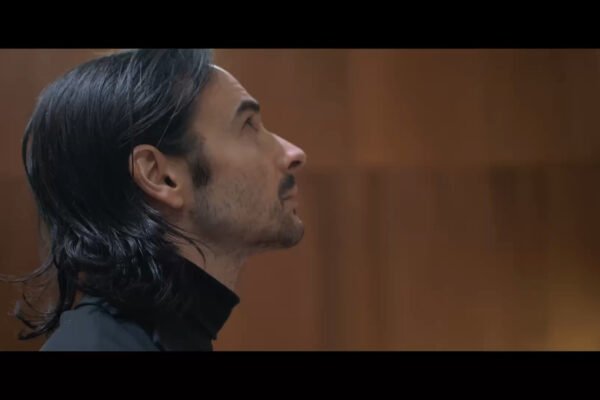 A man with long hair gazes upward, captured in a moment of contemplation, showcasing commercial videography skill.