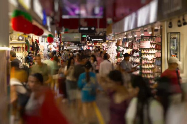 Busy food market scene with shoppers browsing various stalls, showcasing the vibrant atmosphere of commercial photography.