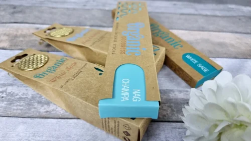 Organic incense packaging featuring Nag Champa scent, presented on a rustic wooden surface with a flower.