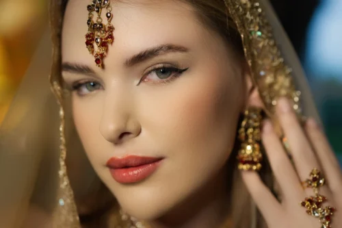A close-up portrait of a woman wearing traditional jewellery and an elegant veil, showcasing stunning beauty and artistry.