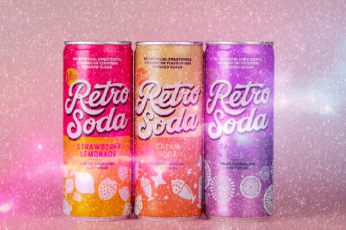 Retro Soda cans in strawberry lemonade, cream soda, and grape flavours against a sparkling pink background.