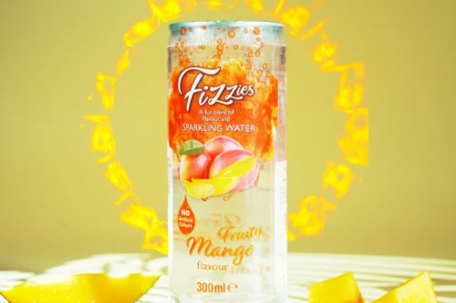 Fizzy mango-flavour sparkling water can surrounded by vibrant yellow, showcasing refreshing beverage in a bright setting.