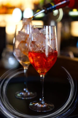 Two glasses filled with ice and a vibrant drink, highlighting enticing food and drink photography for commercial use.